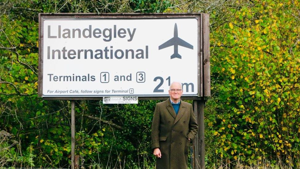 Nicholas Whitehead standing in front of the Llandegley International sign