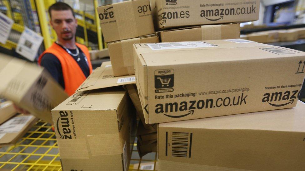 Amazon branded cardboard boxes being handled in one of the online retailers warehouses