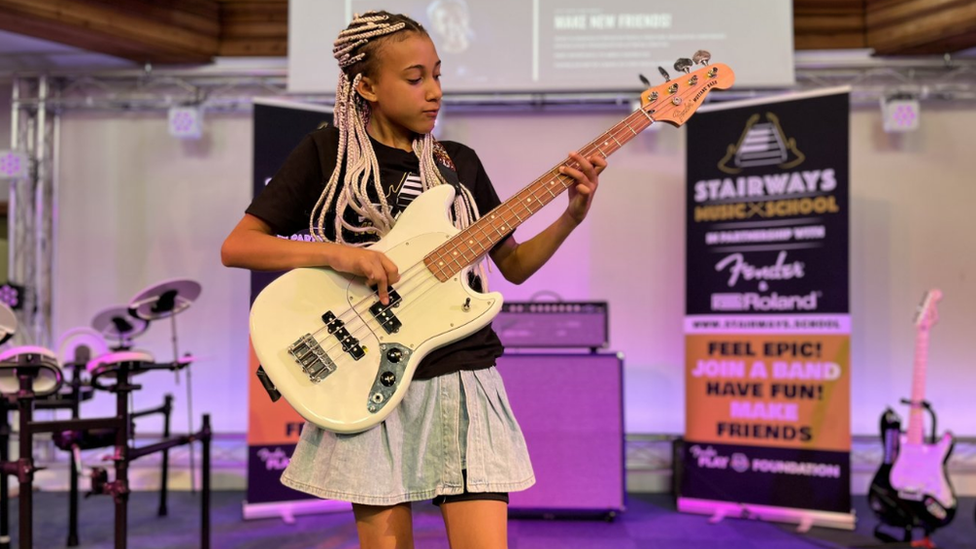 Nandi Bushell playing the guitar