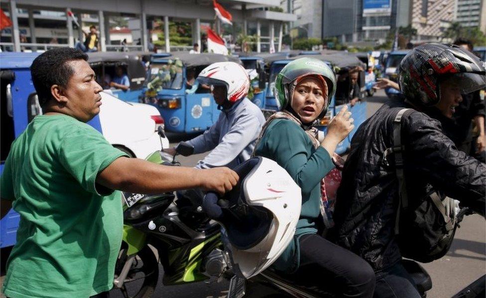 A man hits a motorbike taxi driver in Jakarta