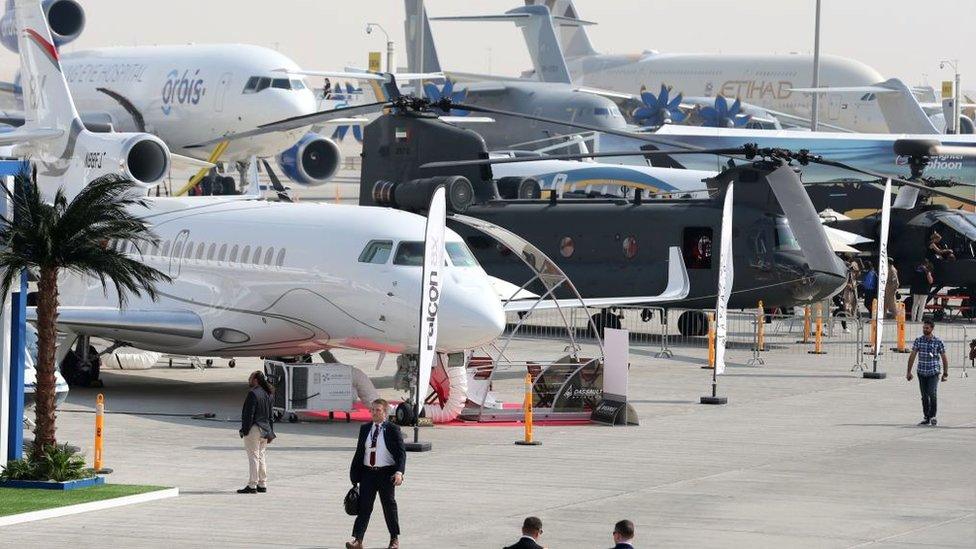 Participants walk past aircrafts during the Dubai Airshow on November 12, 2017, in the United Arab Emirates