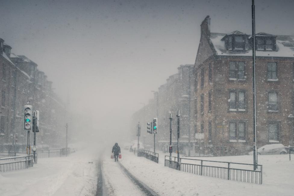 A lone figure walks through a blizzard