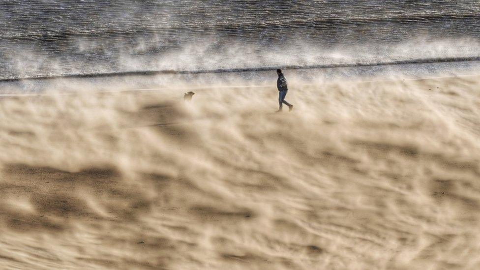 A walker battles strong winds at Tynemouth beach