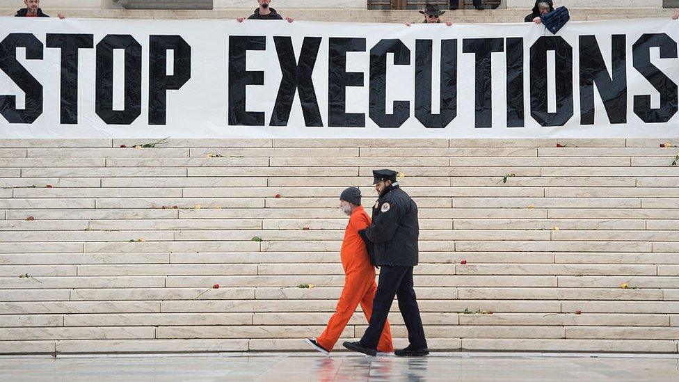 Protesters erecting a large banner reading "stop executions" outside the US Supreme Court in 2017