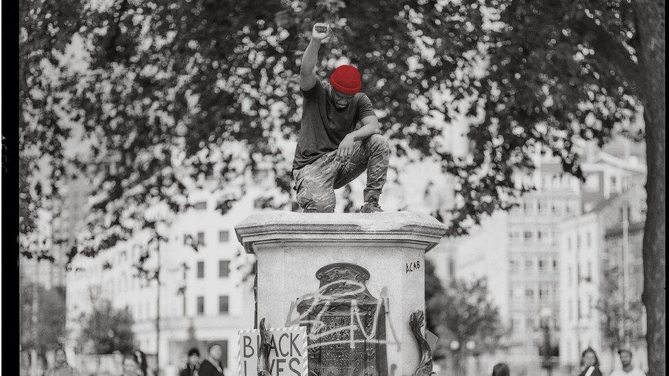 Manoel Akure standing on the plinth after the statue was pulled down