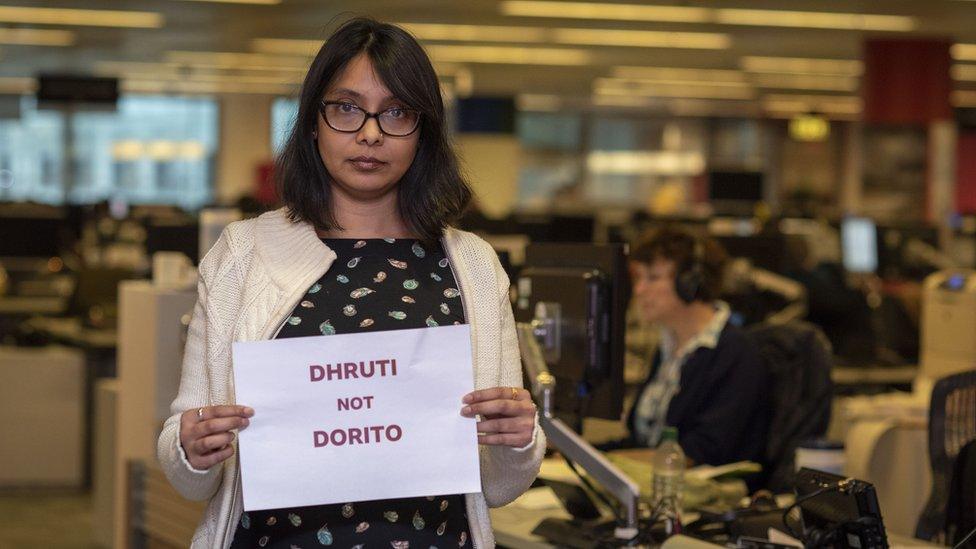 Dhruti Shah holding a picture saying "Dhruti not Dorito"