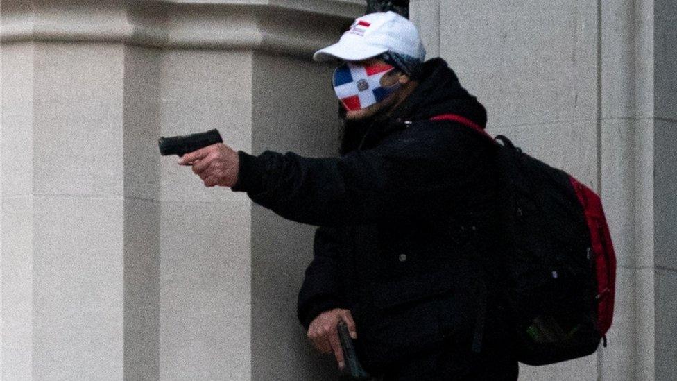 A Reuters photograph showing the gunman, carrying two pistols and wearing a face mask sporting the flag of the Dominican Republic