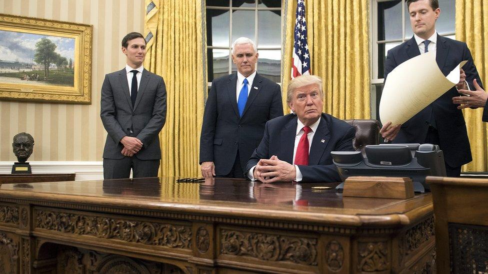 President Donald Trump prepares to sign a confirmation for Defense Secretary James Mattis in the Oval Office