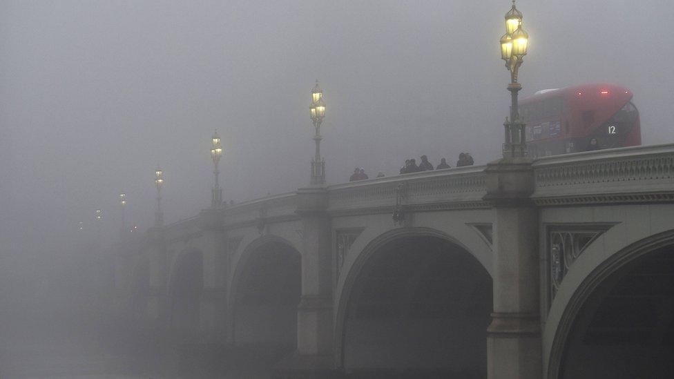 London bus travelling over Westminster Bridge in fog