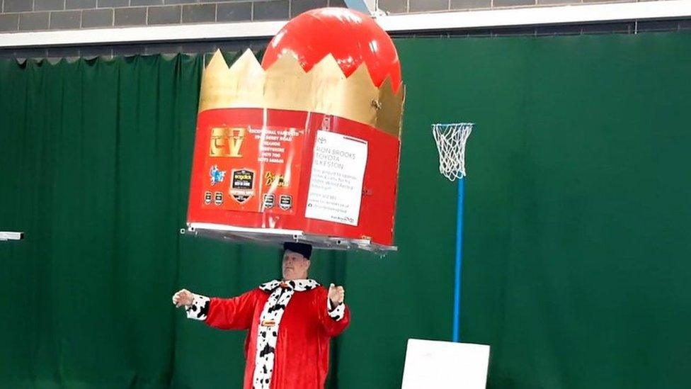 John balancing a huge crown on his head for 100th world record attempt