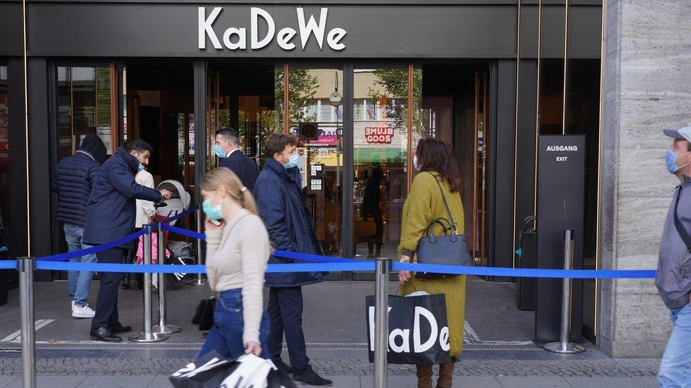 masked people walk past German department store KaDeWe