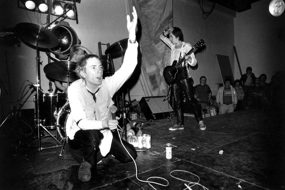 8th December 1976: The Sex Pistols: Johnny Rotten (John Lydon), Paul Cook (drums) and Steve Jones (guitar) performing on stage at Leeds Polytechnic, UK.