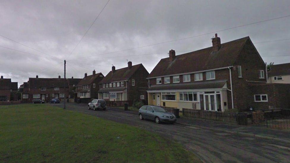 Semi-detached houses next to a green