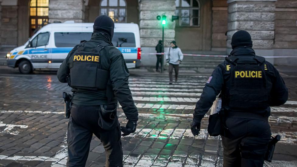 Police officers walk around a building in Charles University in Prague, Czech Republic