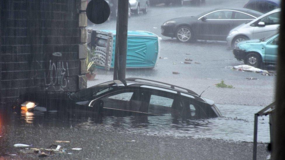 A car is submerged in floodwaters in Catania