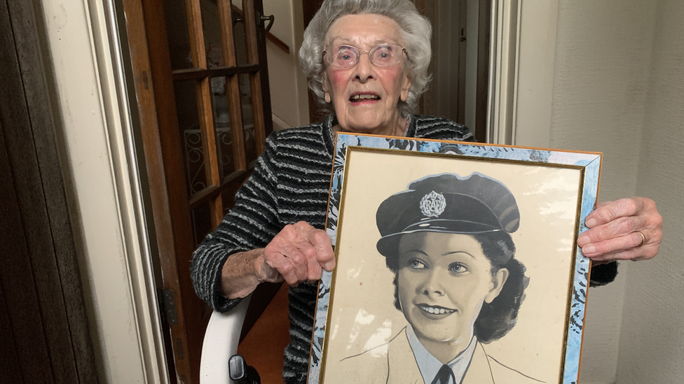 Jean McKay holding an old portrait of herself