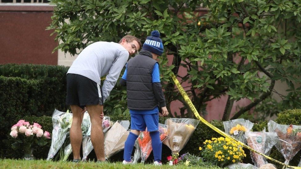 Residents bring flowers to a makeshift memorial at the Tree of Life synagogue