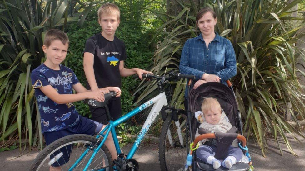 Oksana with children Vladislav, Dmitro and Stanislav and their refurbished bike