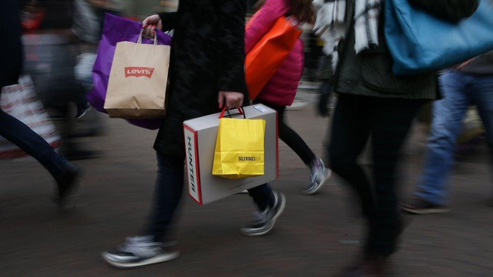 Shoppers carry bags from retailers including Levi's and Selfridge's as they walk along Oxford Street in London, on November 24, 2017.