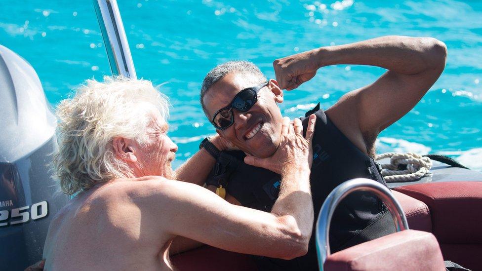 Former US President Barack Obama and British businessman Richard Branson sit on a boat in the British Virgin Islands