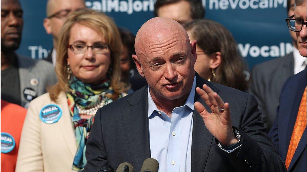 Gun violence victim and former U.S. Congresswoman Gabby Giffords watches her husband, NASA astronaut Mark Kelly, speak as they visits City Hall on her 2016 Vocal Majority Tour on October 17, 2016 in New York City