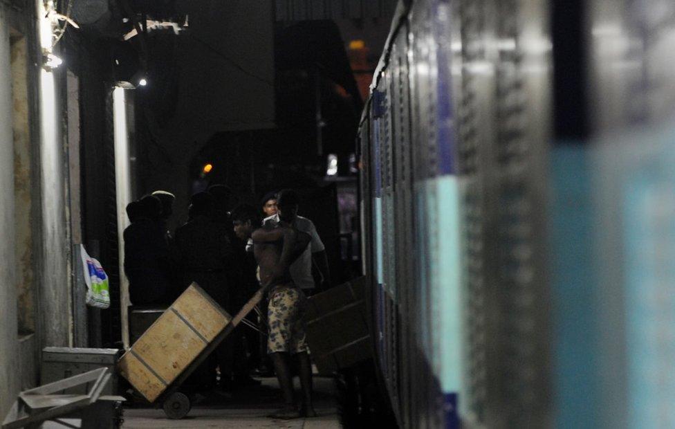 An Indian worker removes a case containing Indian currency from the Salem-Chennai Express train, which was robbed while in transit, at Egmore Railway station in Chennai on August 9, 2016.