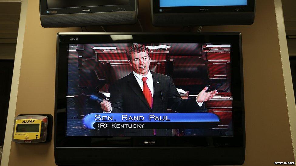 A television shows Rand Paul speaking from the Senate floor.