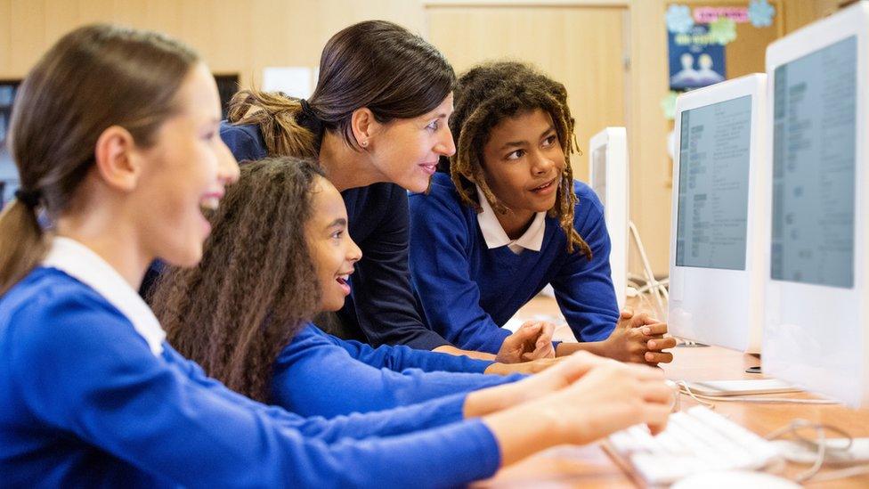 school-pupils-and-teacher-looking-at-computer.