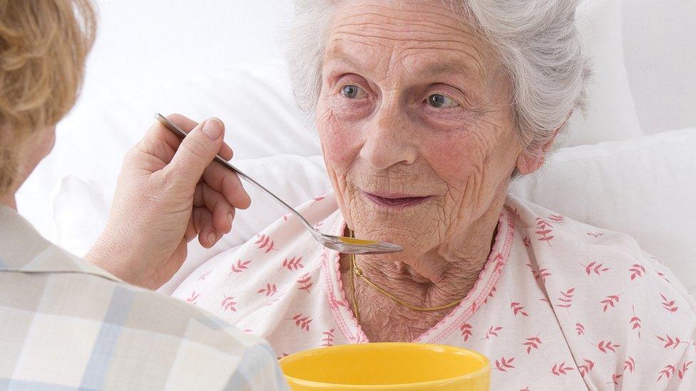 Old woman being fed