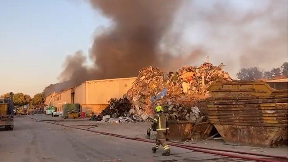 Smoke coming from a large building on a recycling plant