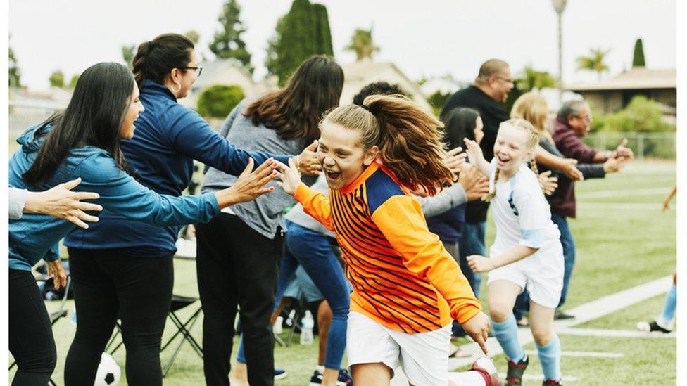 Girl running and cheering with team