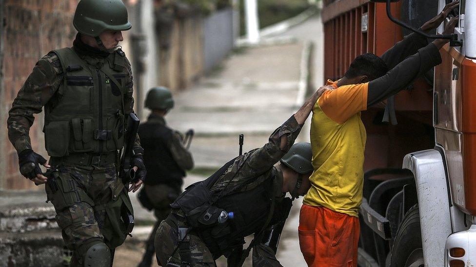 Law enforcement officers search a man in Niteroi, in the metropolitan region of Rio de Janeiro, Brazil, 16 August 2017