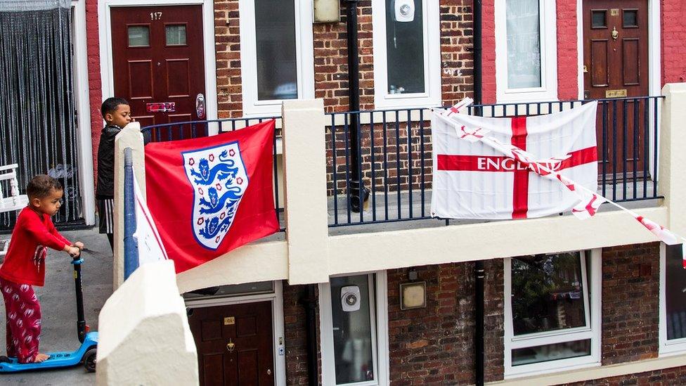 Children outside flats adorned with England flags