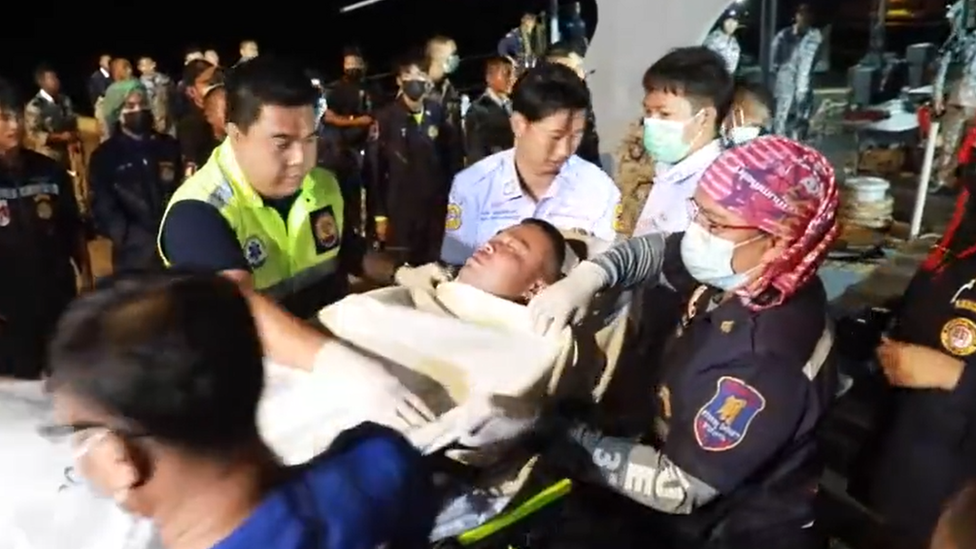 A survivor is taken off a rescue ship in stretcher at the Bang Saphan pier on 19 December