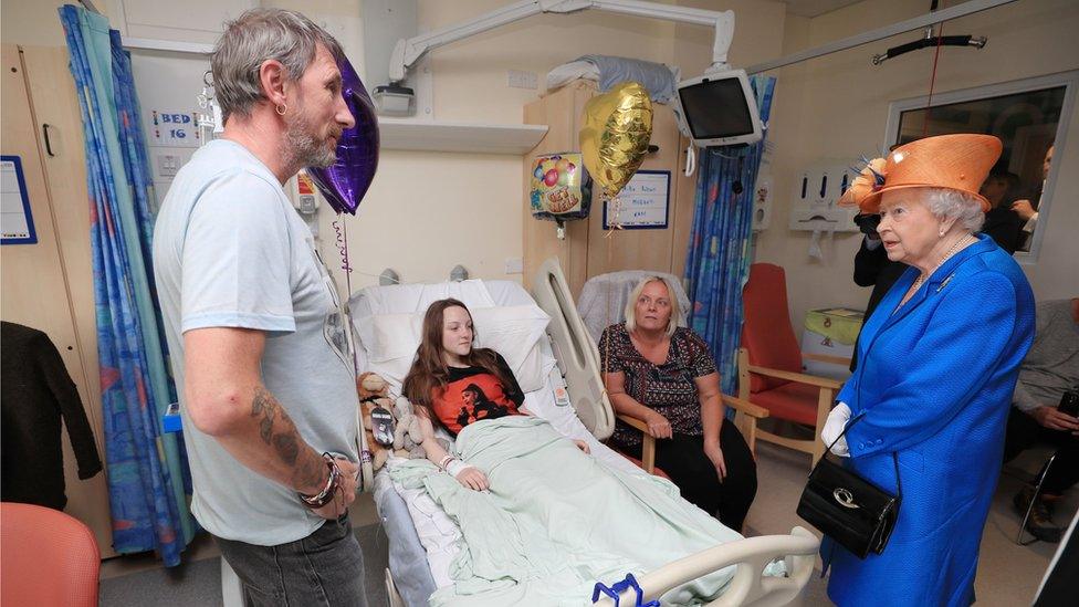 The Queen speaking Millie Robson, 15, her mother, Marie and father David during a visit to Manchester Children's Hospital