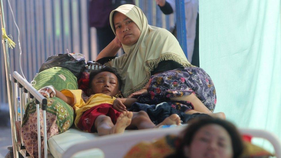 A mother accompanies her injured son at a hospital in Tanjung, northern Lombok, West Nusa Tenggara, Indonesia, 8 August 2018