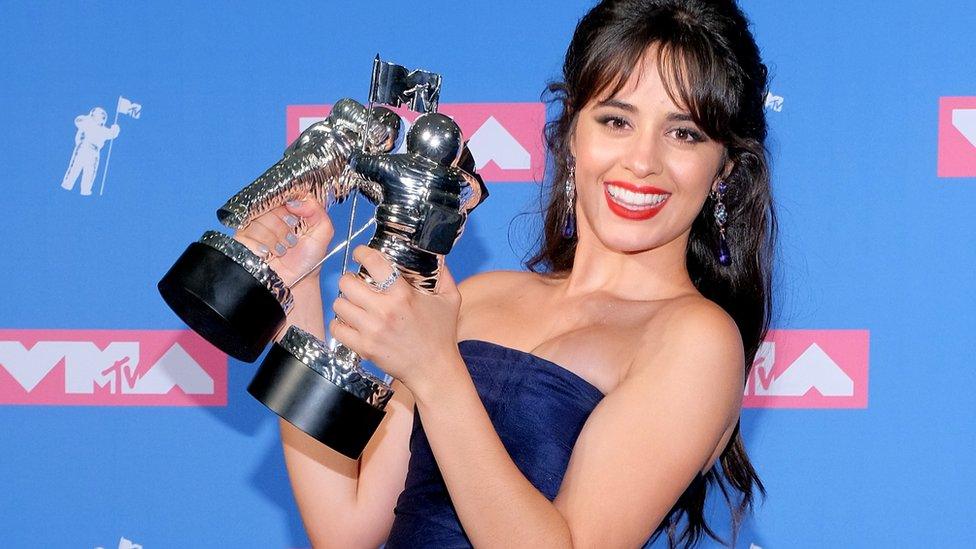 Camila Cabello holding her two trophies