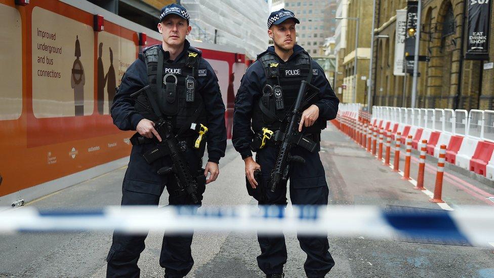 Armed police guarding a road closed near the attack