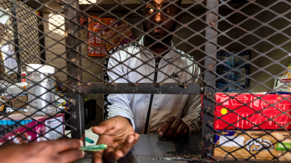 Getachew Desta behind the cage in his shop in Alexandra township, Johannesburg, South Africa