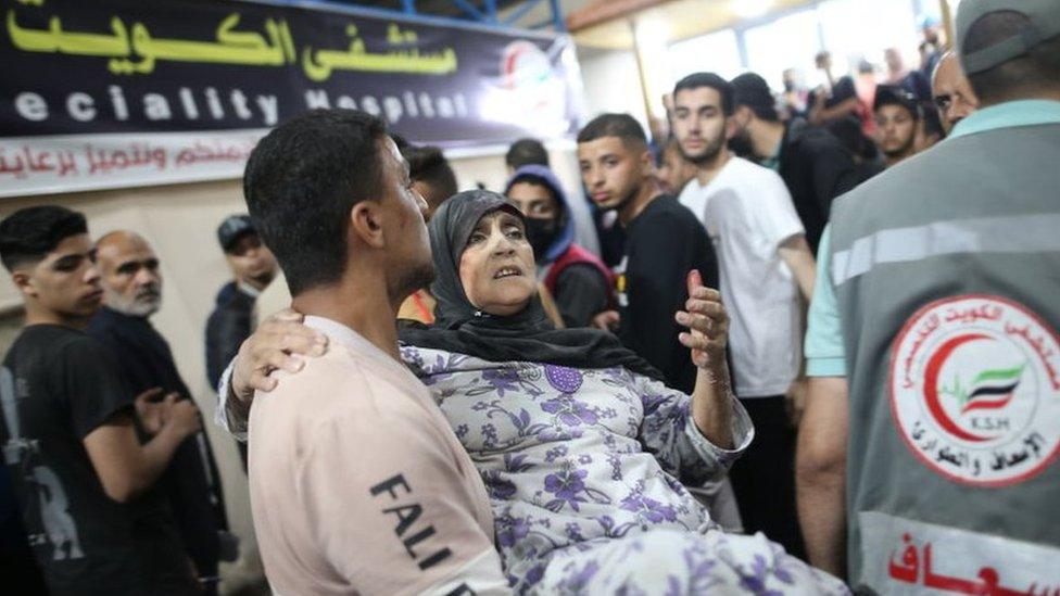 An elderly woman is carried into the Kuwaiti Specialist Hospital in Rafah, in the southern Gaza Strip (8 May 2024)