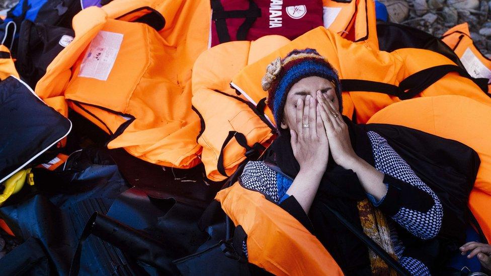 A woman reacts shortly after arriving with other migrants and refugees on the Greek island of Lesbos, after crossing the Aegean sea from Turkey, on October 14, 2015.