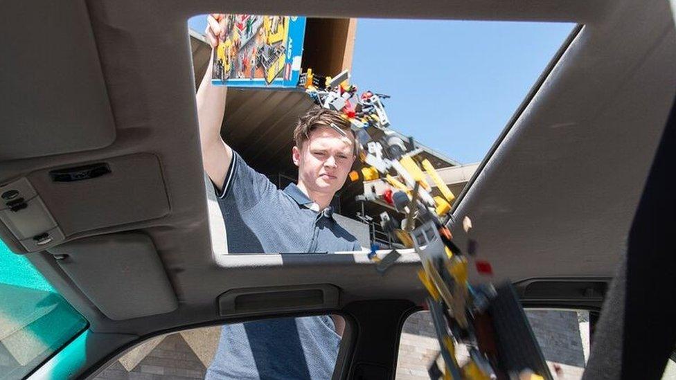 A man pours Lego into a car at a gallery in Australia