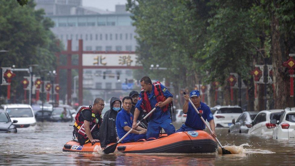 People ride a rubber boat to eascpe floods in Beijing, China due to super typhoon Doksuri