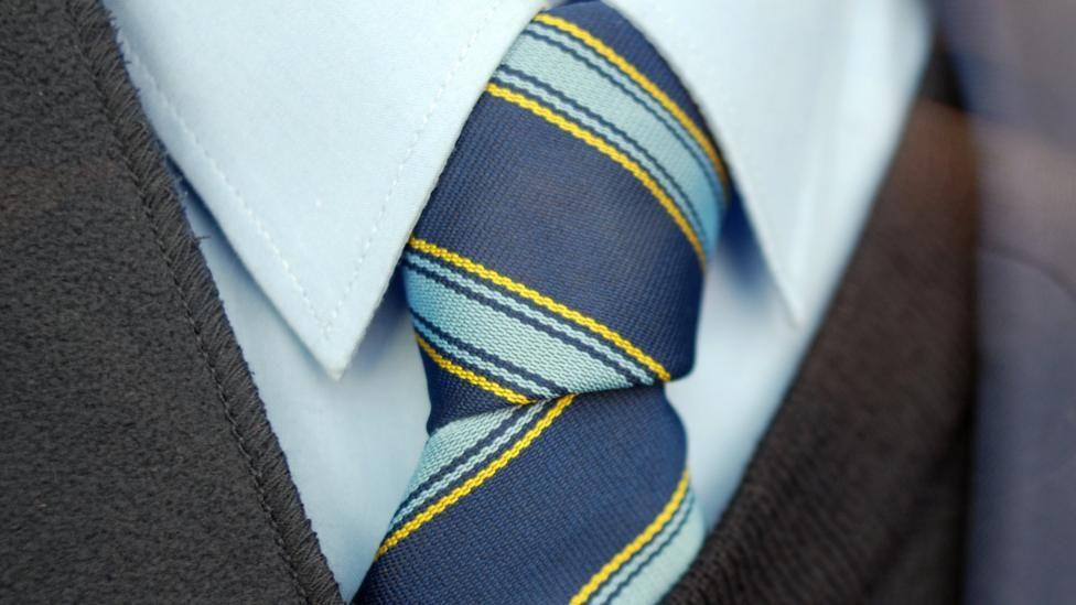 A close up picture of a school tie, jumper and shirt collar