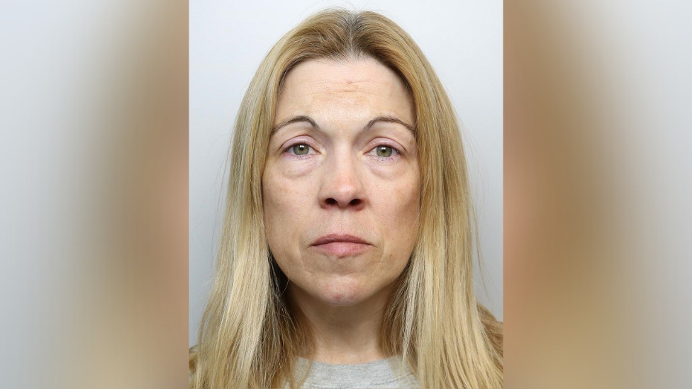 Catherine Pearl mugshot. She has long blonde hair and is stood in front of a grey wall.