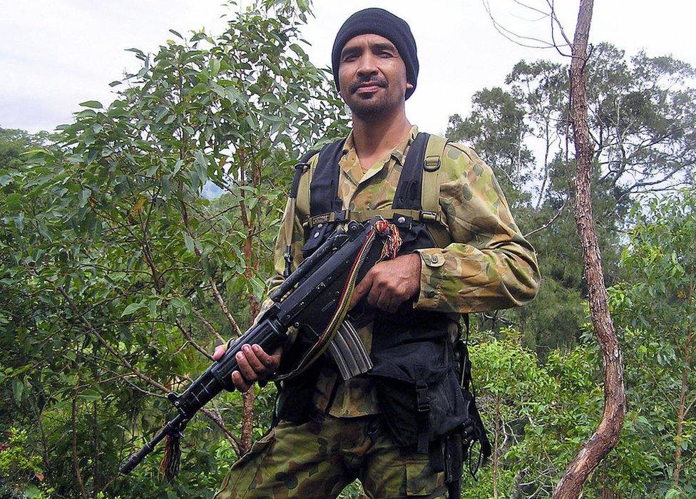 The fugitive rebel leader, Major Alfredo Reinado, poses for photographers, wearing Australian military fatigues and holding a weapon, in the forest in Same, 50 kilometres (30 miles) south of the capital Dili, 12 March 2007.