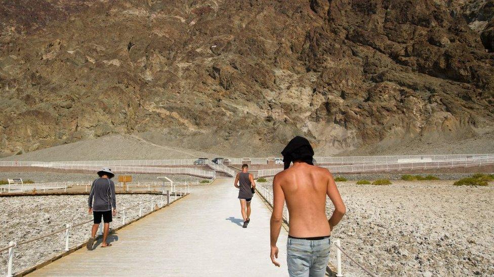 Visitors walk by the salt flats of Badwater Basin inside Death Valley National Park