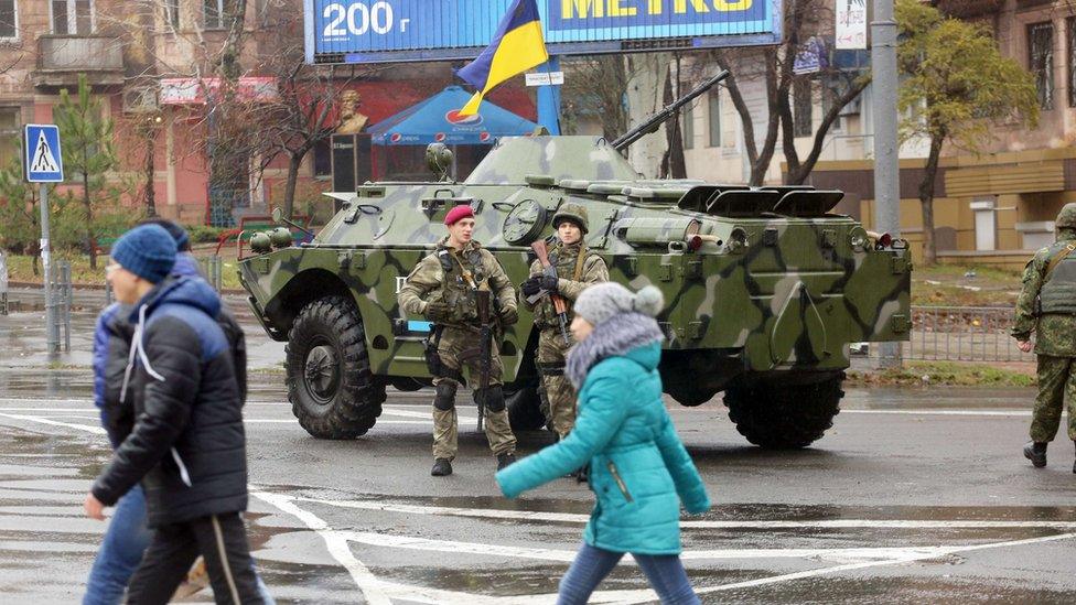 Ukrainian servicemen stand guard at one of the city of Mariupol's polling stations, in the Donetsk region