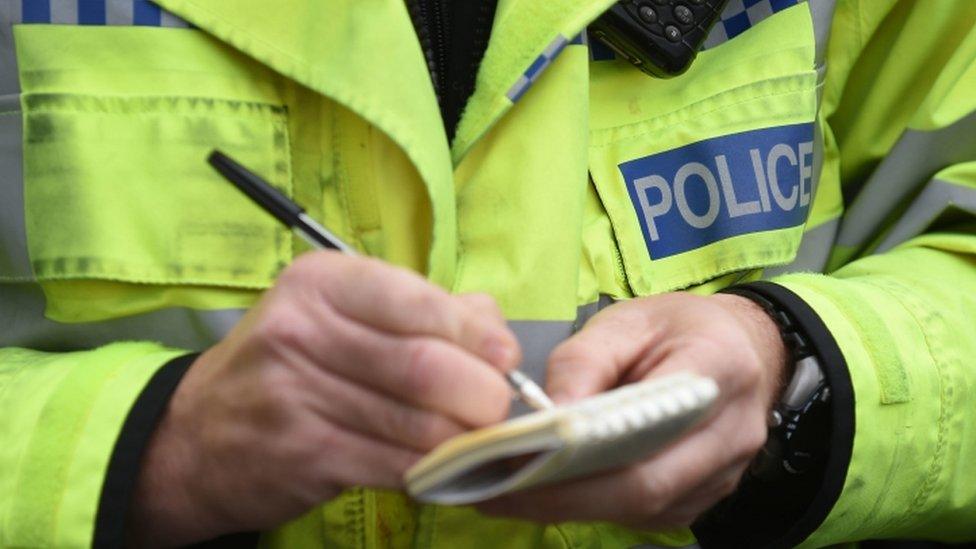 Police officer writing in note book