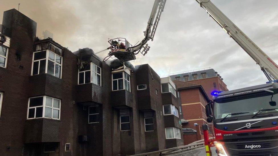 Firefighters on a crane platform extinguish the blaze at Carliol Square